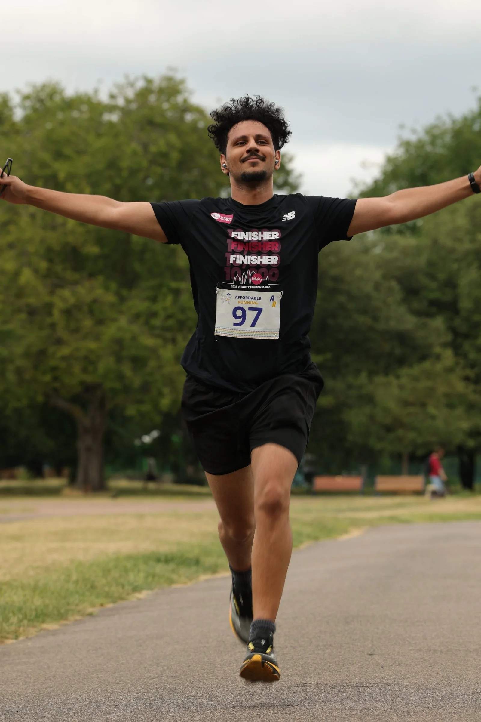 A 10K finisher with his arms out